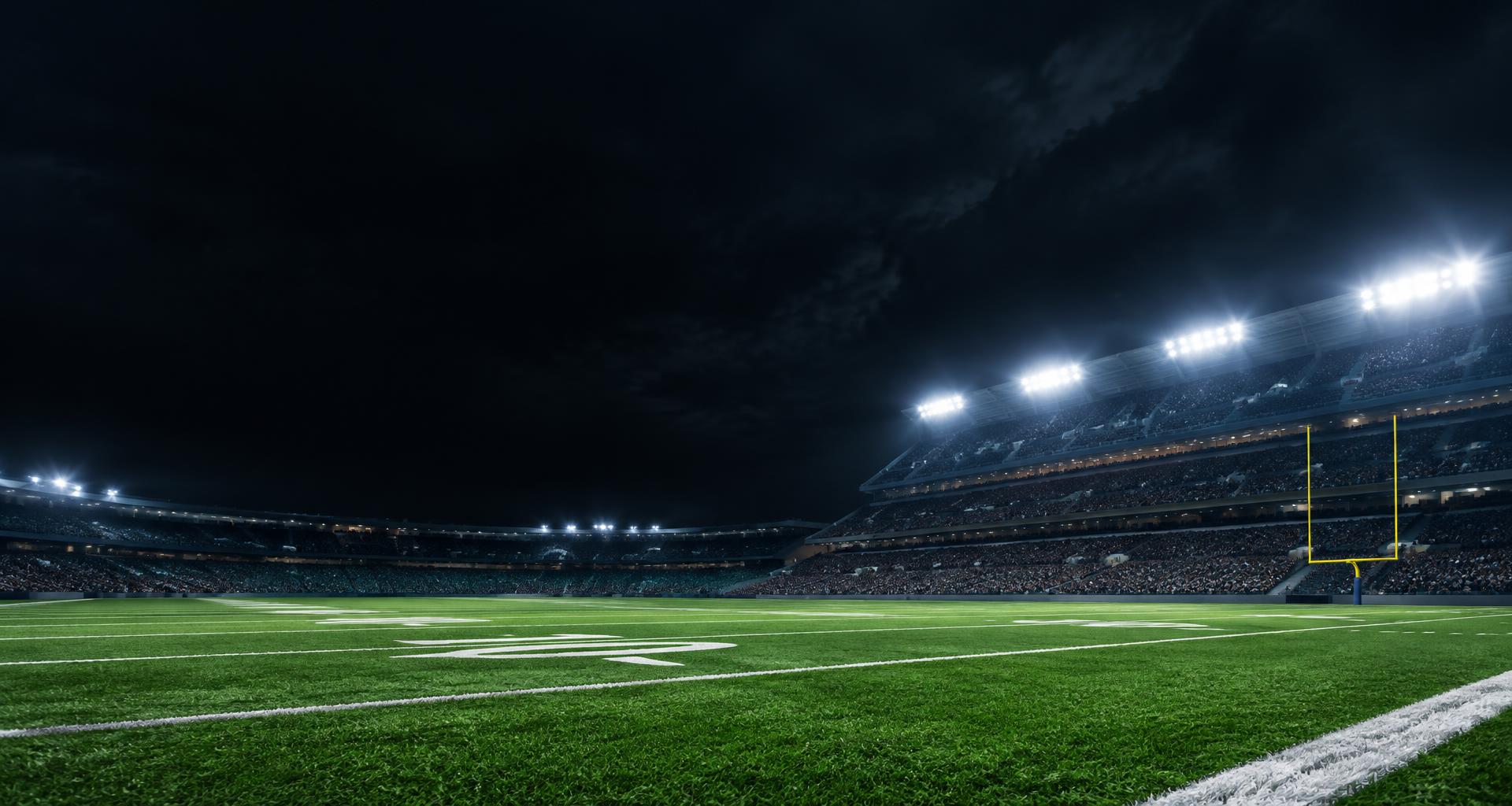 Floodlit football stadium and field at night
